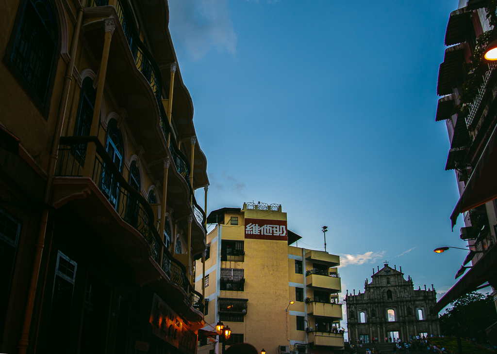 A yellow building with Vita Soy logo at the top near the St. Paul's Cathedral Ruins in Macau.